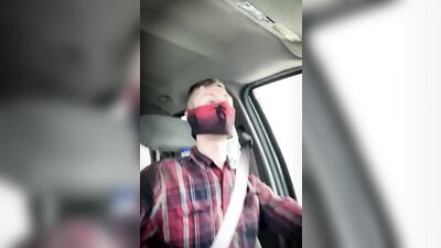 Amateur masked bloke is having fun while driving a car