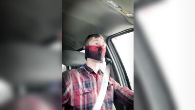 Amateur masked bloke is having fun while driving a car