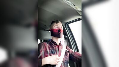 Amateur masked bloke is having fun while driving a car