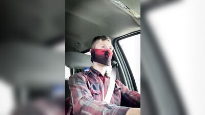 Amateur masked bloke is having fun while driving a car