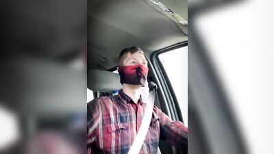 Amateur masked bloke is having fun while driving a car