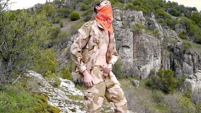 Skinny masked chap is playing with a dick on top of the mountain
