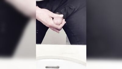 Perverted fellow is playing with a penis inside the public bathroom
