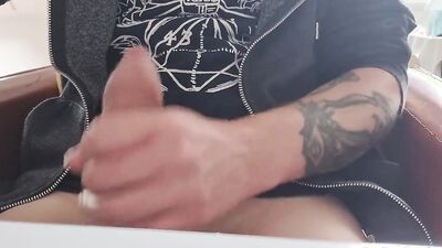 Tattooed fellow is jerking his dick in front of the phone