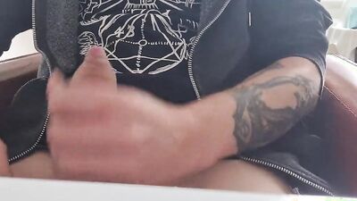 Tattooed fellow is jerking his dick in front of the phone
