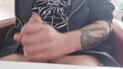 Tattooed fellow is jerking his dick in front of the phone