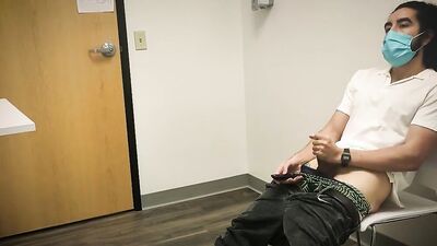 Bearded chap is stroking his hard prick inside the sperm bank
