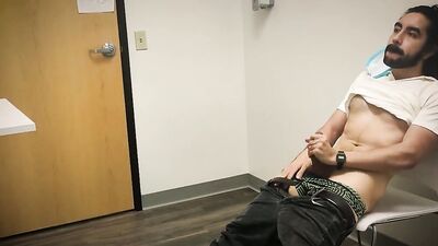 Bearded chap is stroking his hard prick inside the sperm bank