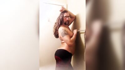 Longhaired fella is flashing his butt cheeks in front of the mirror