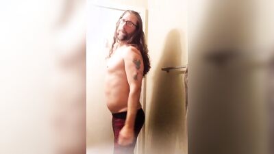 Longhaired fella is flashing his butt cheeks in front of the mirror