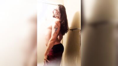 Longhaired fella is flashing his butt cheeks in front of the mirror