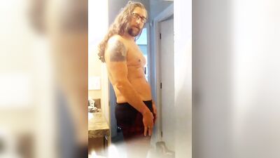Longhaired fella is flashing his butt cheeks in front of the mirror