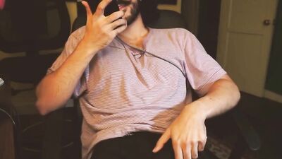 Curly haired bloke is masturbating in front of the phone