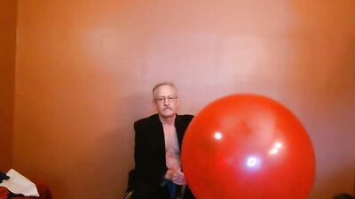 Perverted grandpa is playing with huge balloon in front of the cam