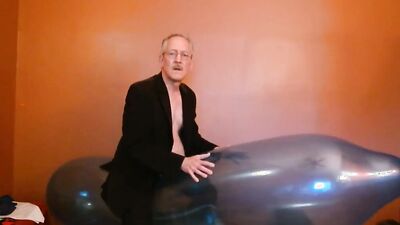 Perverted grandpa is playing with huge balloon in front of the cam
