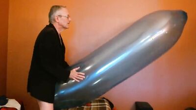 Perverted grandpa is playing with huge balloon in front of the cam