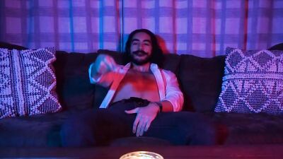 Longhaired mustache dude ia jerking his willy on the couch