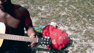 Amateur African chap is playing a guitar in front of the cam