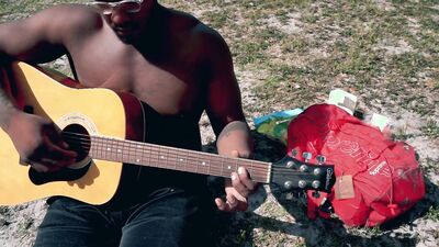 Amateur African chap is playing a guitar in front of the cam