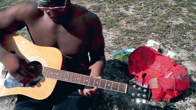 Amateur African chap is playing a guitar in front of the cam
