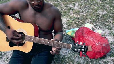 Amateur African chap is playing a guitar in front of the cam