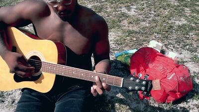 Amateur African chap is playing a guitar in front of the cam