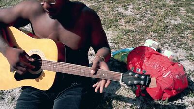 Amateur African chap is playing a guitar in front of the cam