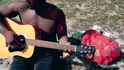 Amateur African chap is playing a guitar in front of the cam
