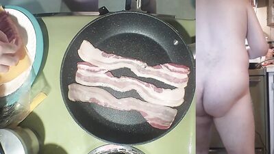Perverted amater bloke is making a becon and eggs sandwich naked