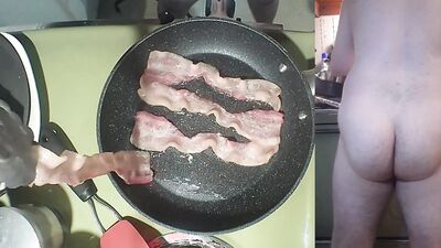 Perverted amater bloke is making a becon and eggs sandwich naked
