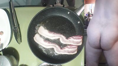 Perverted amater bloke is making a becon and eggs sandwich naked