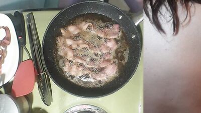 Perverted amater bloke is making a becon and eggs sandwich naked