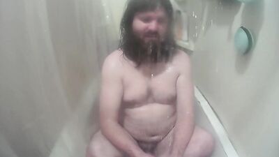 Longhaired chubby fellow is jerking his prick inside the hot shower
