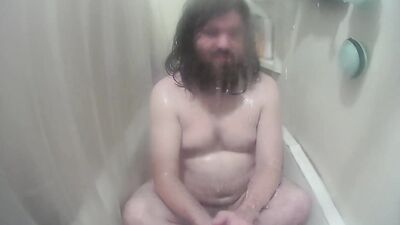 Longhaired chubby fellow is jerking his prick inside the hot shower