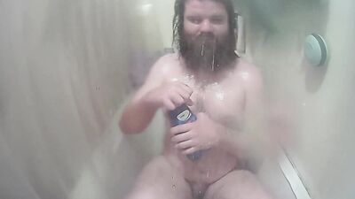 Longhaired chubby fellow is jerking his prick inside the hot shower