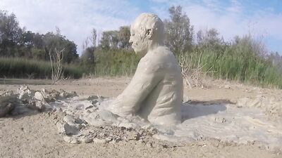 Perverted bloke is having fun out in the open inside the mud