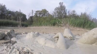 Perverted bloke is having fun out in the open inside the mud