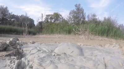Perverted bloke is having fun out in the open inside the mud