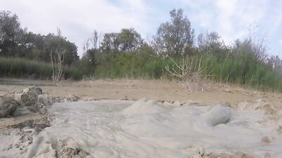 Perverted bloke is having fun out in the open inside the mud