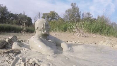 Perverted bloke is having fun out in the open inside the mud