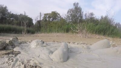 Perverted bloke is having fun out in the open inside the mud