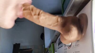 Horny dude is wrapping his fuck gole around big gummy dildo