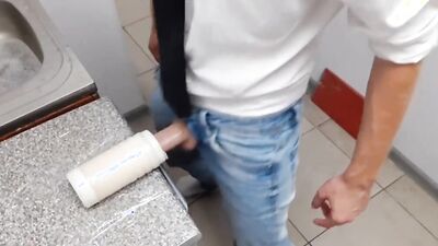 Lad plays with a plastic puss inside the public restroom
