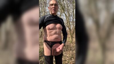 Old gay fellow is playing with his dong in the forest