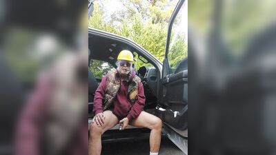 Perverted electrician is playing with his pecker next to the car