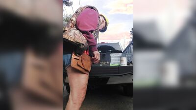 Perverted electrician is playing with his pecker next to the car