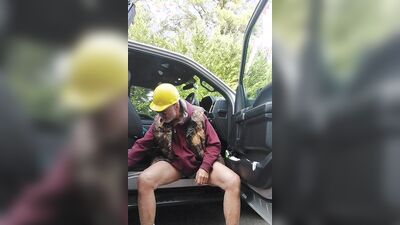 Perverted electrician is playing with his pecker next to the car
