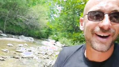 Perverted dude is playing with his dick next to a river