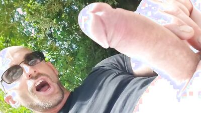 Perverted dude is playing with his dick next to a river