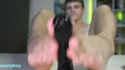Perverted bloke is stroking gummy black toy with his feet